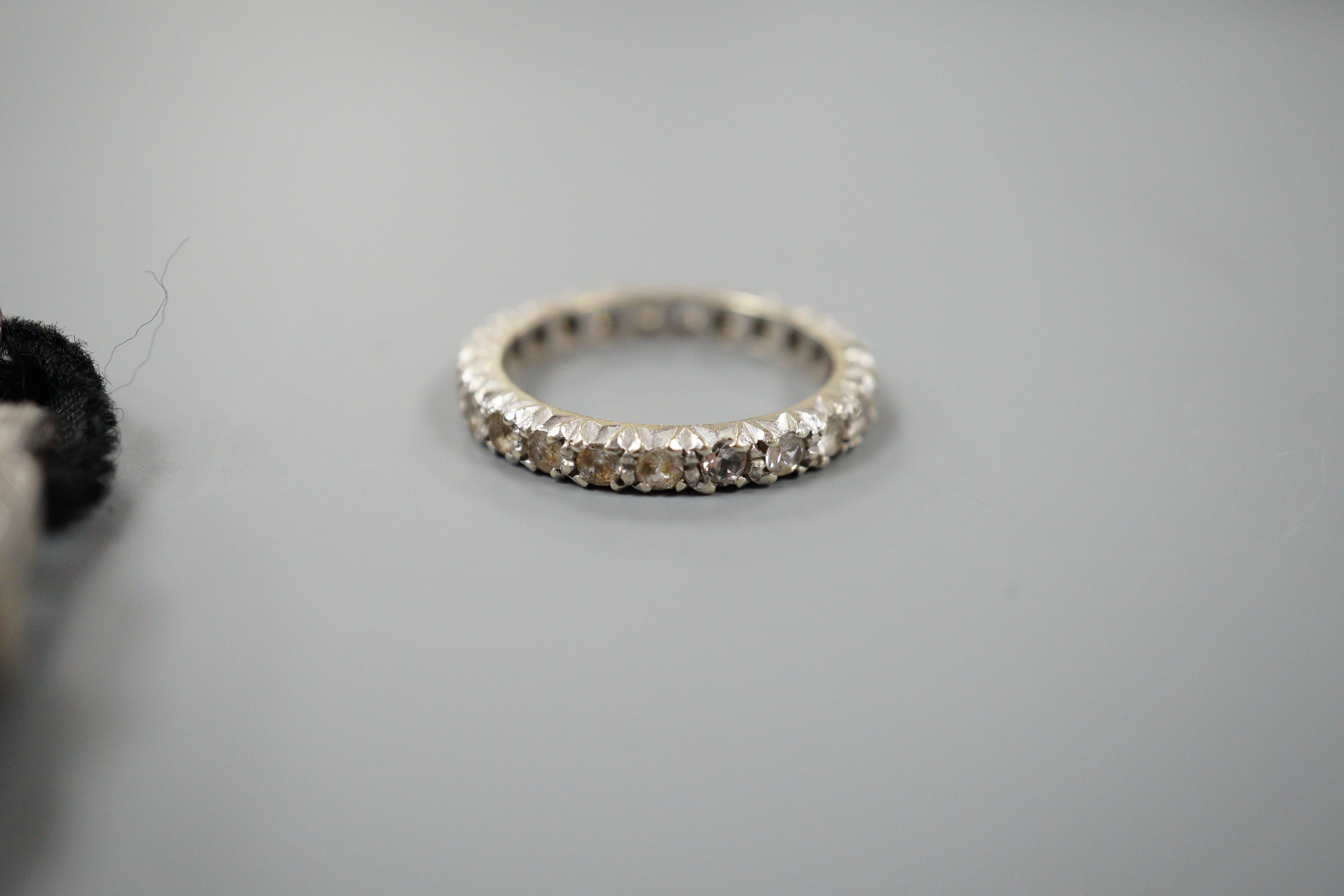 A lady's white metal (stamped all platinum) and diamond set manual wind cocktail watch, gross weight 13.2 grams and a 9ct white metal and synthetic white spinel set full eternity ring.